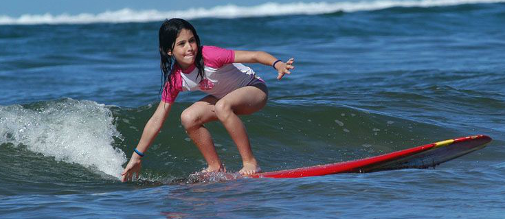 Young girl surfing in crouched position