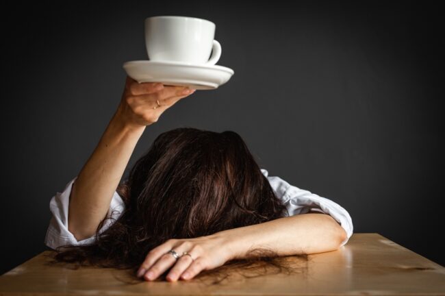 Women holding coffee cup over head