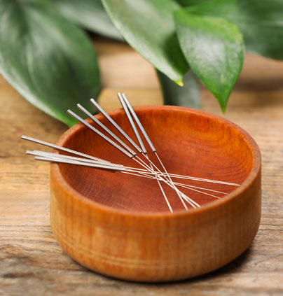 Acupuncture needles in wooden bowl