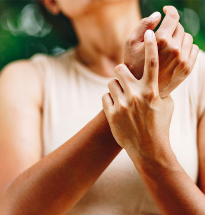 women holding wrist looking anguished